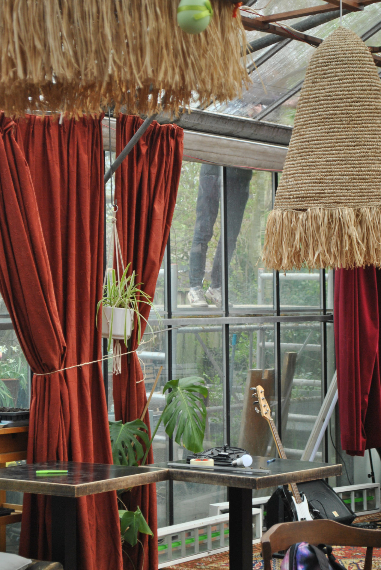scenery an image inside our green house, showing someone working outside, red curtains and a lone guitar.